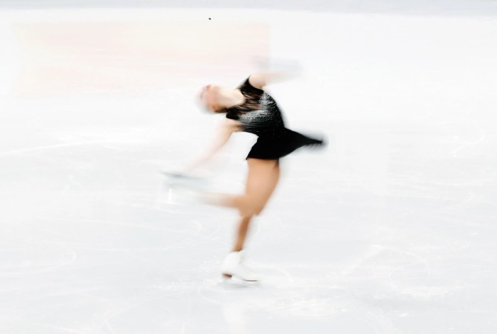A figure skater begins spinning counterclockwise